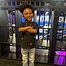 Syeir is registered to the contest to win money with this photo: child, smiling, standing, arms_crossed, jeans, sneakers, black_tshirt, necklace, wristband, indoor, graffiti, industrial, metal_bars, colorful, happy, person, portrait, fashion, casual, hair