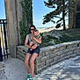 David joined the competition — help win amazing prizes! woman, baby, beach, sand, stone_wall, tree, sunglasses, green_sneakers, casual_clothing, outdoor, sunny, smiling_baby, holding, nature, sky, dunes, vacation, relaxation, portrait, daytime