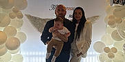 David is registered to the contest to win money with this photo: family, baby, man, woman, balloons, indoor, celebration, angel_wings, floor, window, light, clothing, shoes, curtains, smile, portrait, decor, people, holding, happy