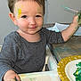 Ethan participe au concours pour gagner de l'argent avec cette photo : toddler, child, paint, messy, high_chair, face_paint, paintbrush, hand_paint, smile, striped_shirt, indoor, table, plate, foot, floor, hair, expression, art, creative, play