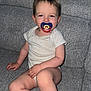 toddler, child, pacifier, sitting, couch, indoor, home, smile, white_clothing, infant, furniture, living_room, cute, baby, person, young_child, relaxing, face, skin, legs