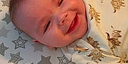 Aiden joined the competition — help win amazing prizes! baby, smiling, face, infant, clothing, pattern, animal_print, star_pattern, changing_pad, happy, cute, lying_down, skin, head, eyes, mouth, cheeks, indoors, child, person