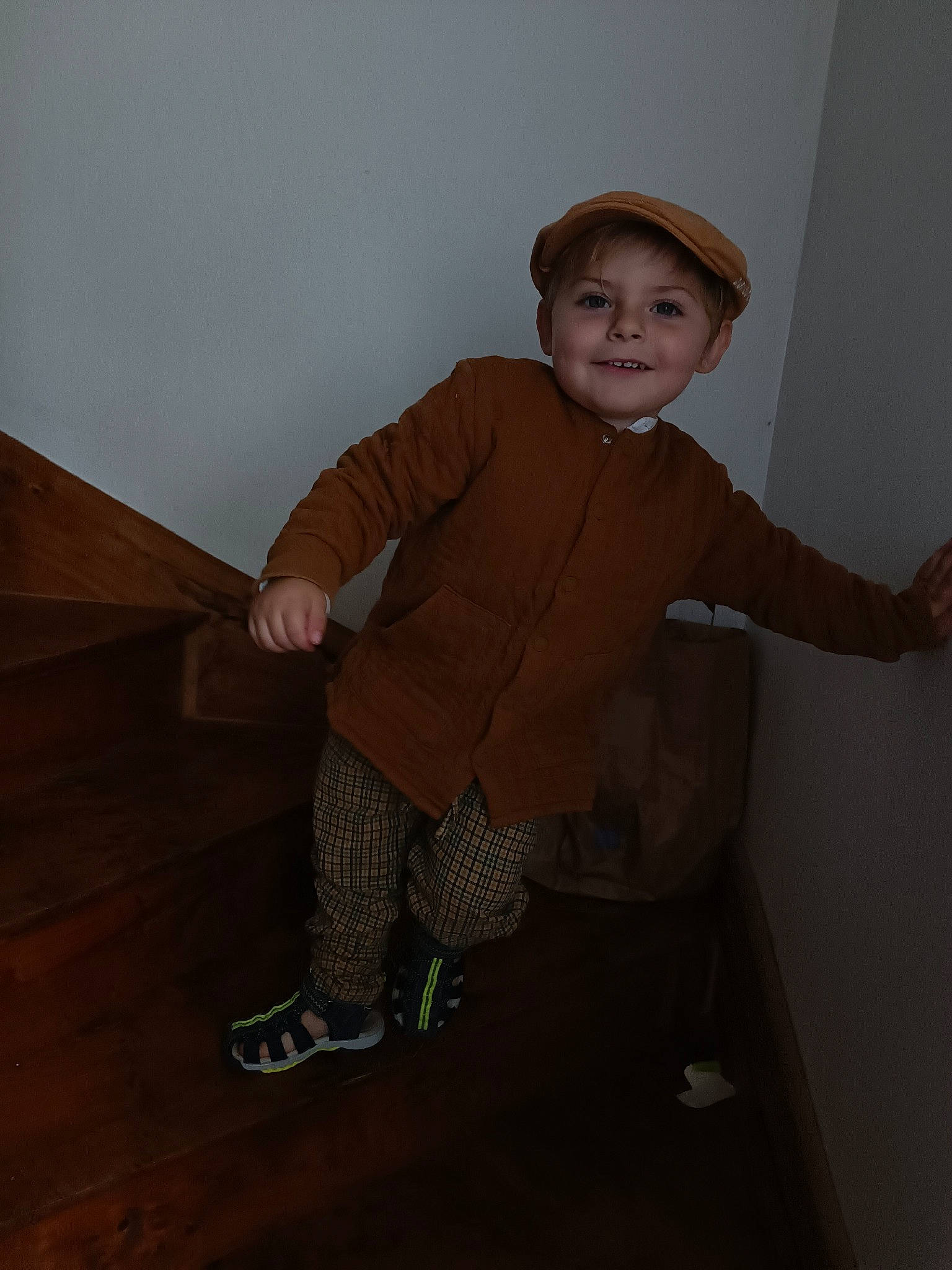 Pablo participe au concours pour gagner de l'argent avec cette photo : baby_toddler_clothing, boot, child, flooring, fun, hardwood, human_leg, joy, knee, outdoor_shoe, pattern, person, personal_protective_equipment, room, sitting, sleeve, smile, sock, thumb, toddler