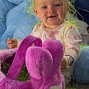 Haizley joined the competition — help win amazing prizes! baby, child, easter_grass, plush_toy, purple_bunny, yellow_toy, green_toy, blanket, blue_blanket, pink_clothing, smiling, indoor, toy, face, happy, sitting, playful, cute, person, colorful