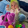 Haizley is registered to the contest to win money with this photo: toddler, child, toy, plush_bunny, rubber_duck, easter_grass, blanket, carpet, indoor, playtime, smiling, colorful, yellow, purple, green, blue, person, cute, happy, baby