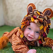 Léo participe au concours pour gagner de l'argent avec cette photo : baby, child, costume, lion, cute, smiling, face, blue_eyes, grass, outdoor, playful, portrait, animal_costume, fabric, headwear, infant, crawling, soft_texture, colorful, happy