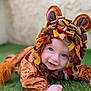 baby, child, costume, lion, cute, smiling, face, blue_eyes, grass, outdoor, playful, portrait, animal_costume, fabric, headwear, infant, crawling, soft_texture, colorful, happy