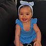 baby, child, blue_dress, headband, bow, smiling, sitting, couch, indoor, red_eye, happy, cute, infant, barefoot, hand, foot, skin, person, face, portrait