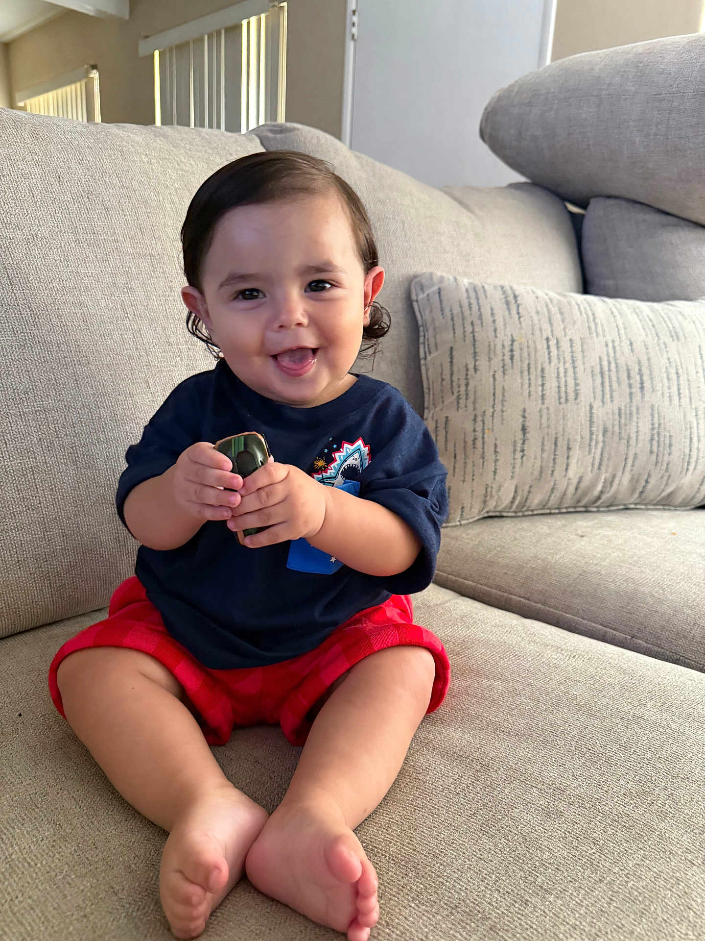 Vincent joined the competition — help win amazing prizes! toddler, child, smiling, toy, car, sitting, couch, indoor, clothing, shorts, shirt, happy, face, feet, hands, hair, home, pillow, furniture, play