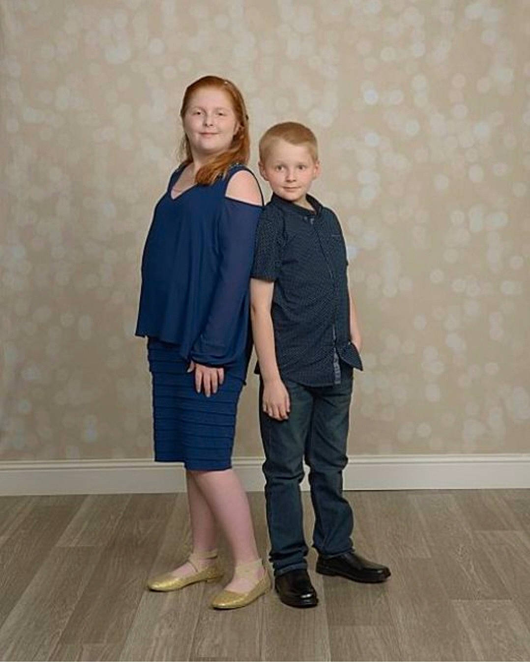 Emma is registered to the contest to win money with this photo: electric_blue, event, fashion_design, flooring, footwear, formal_wear, gesture, happy, human_leg, joy, knee, leg, pattern, person, sandal, sleeve, smile, t_shirt, thigh, toddler