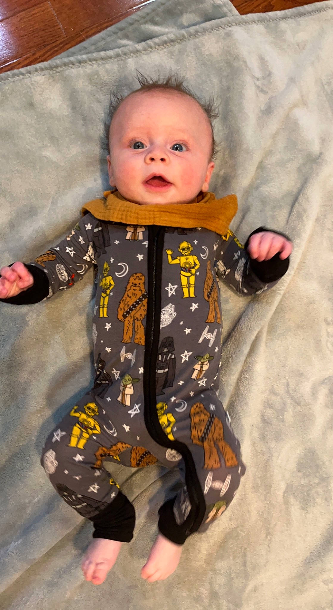 Maverick is registered to the contest to win money with this photo: baby, baby_products, baby_toddler_clothing, cheek, child, collar, comfort, eye, finger, flooring, fun, jacket, linens, outerwear, pattern, person, sitting, skin, sleeve, smile