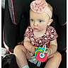 baby, child, car_seat, pink_headband, toy, blue_eyes, leopard_print, clothing, infant, sitting, cute, girl, portrait, indoor, seat, accessory, headwear, holding, person, young