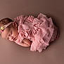 élise participe au concours pour gagner de l'argent avec cette photo : newborn, baby, sleeping, pink_dress, headband, flower, soft_lighting, portrait, infant, peaceful, cute, child, studio_photo, fabric, ruffles, skin, closeup, resting, young, adorable