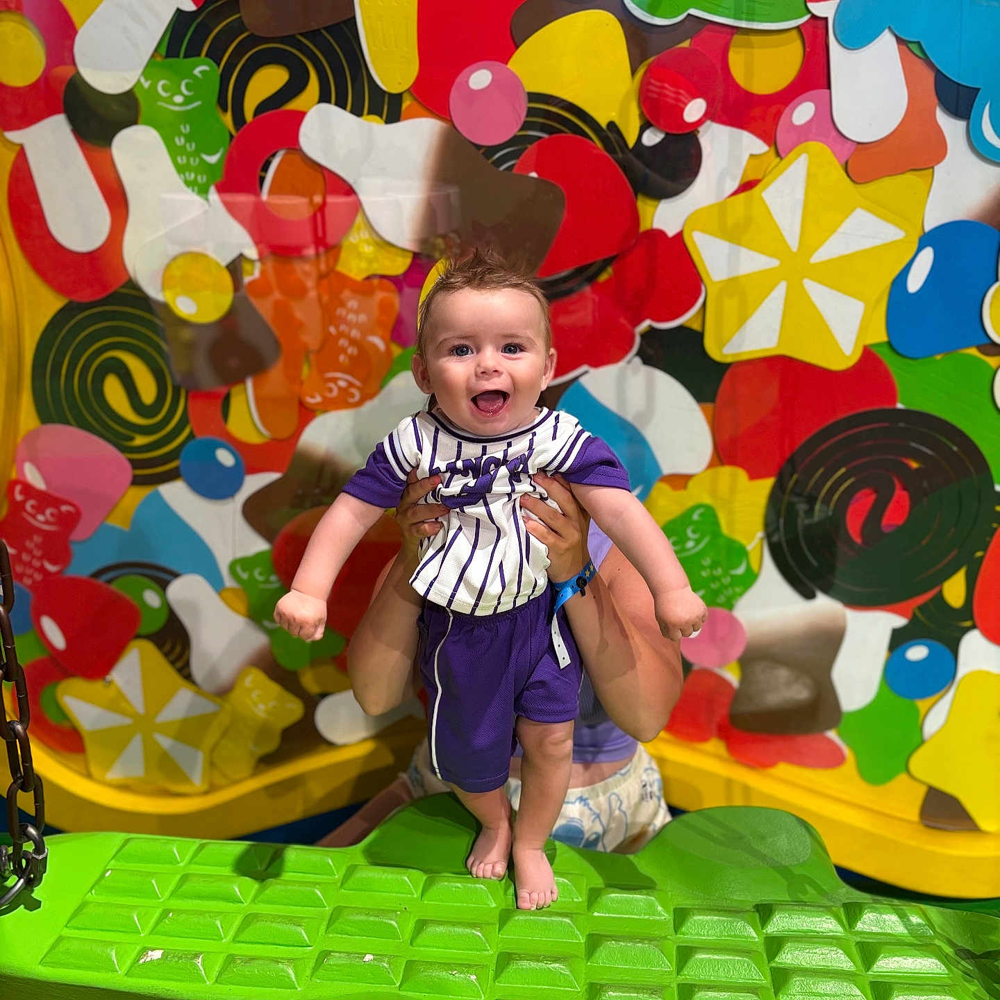 Dawson Tarlet participe au concours pour gagner de l'argent avec cette photo : alligator_seat, baby, bright_colors, cheerful, child, colorful_background, face, feet, fun, hands, happy, holding, indoor, patterned_shirt, person, play, playground, purple_clothing, smiling, toy