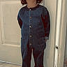 child, toddler, denim_jumpsuit, curly_hair, indoor, door, tile_floor, smile, shoes, moccasins, socks, standing, cute, young_child, fashion, portrait, happy, casual_clothing, headwear, home