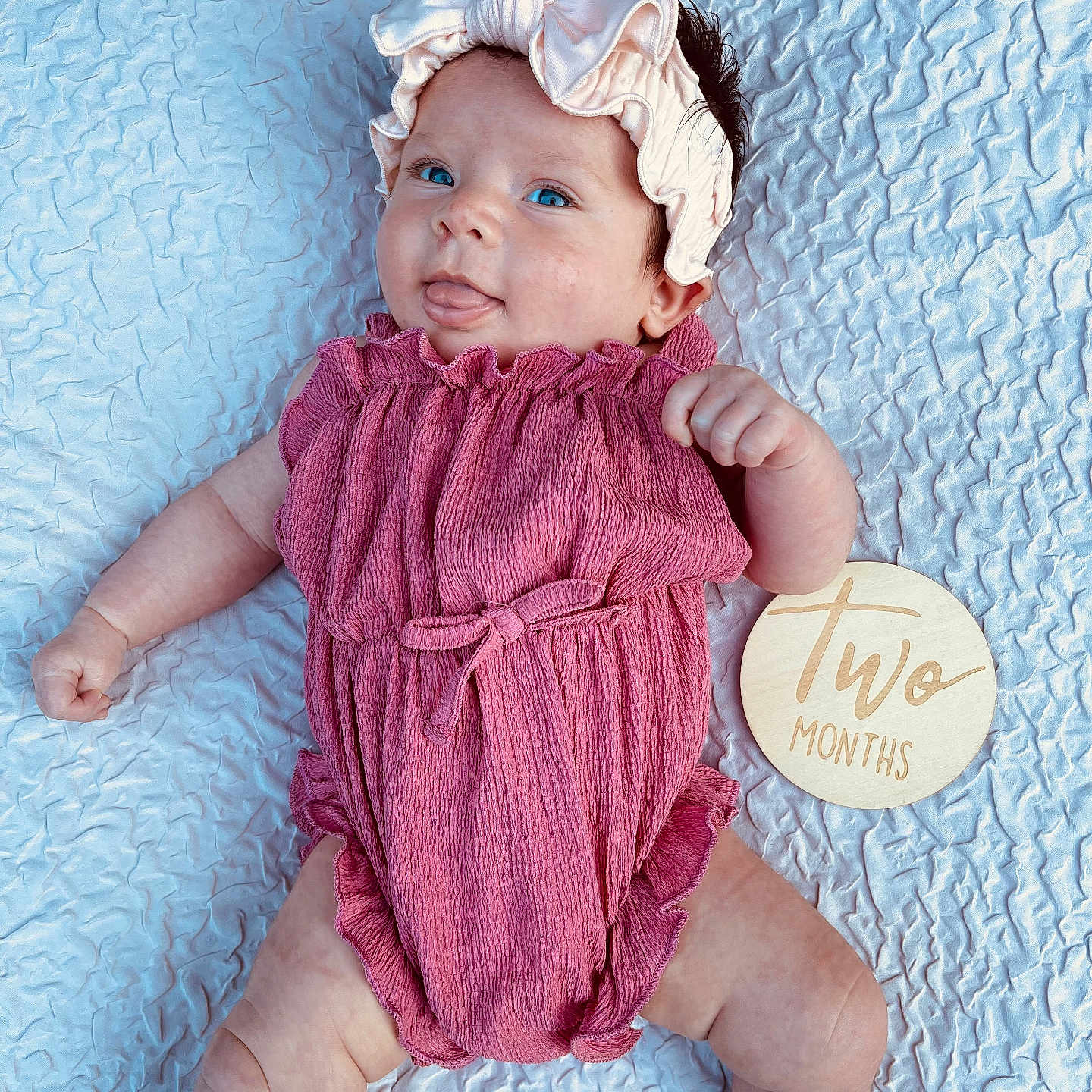 Wrenly is registered to the contest to win money with this photo: baby, bed, blanket, bonnet, cap, clothing, costume, dress, face, furniture, hat, head, knitwear, newborn, person, photography, portrait, purple, sitting, sweater
