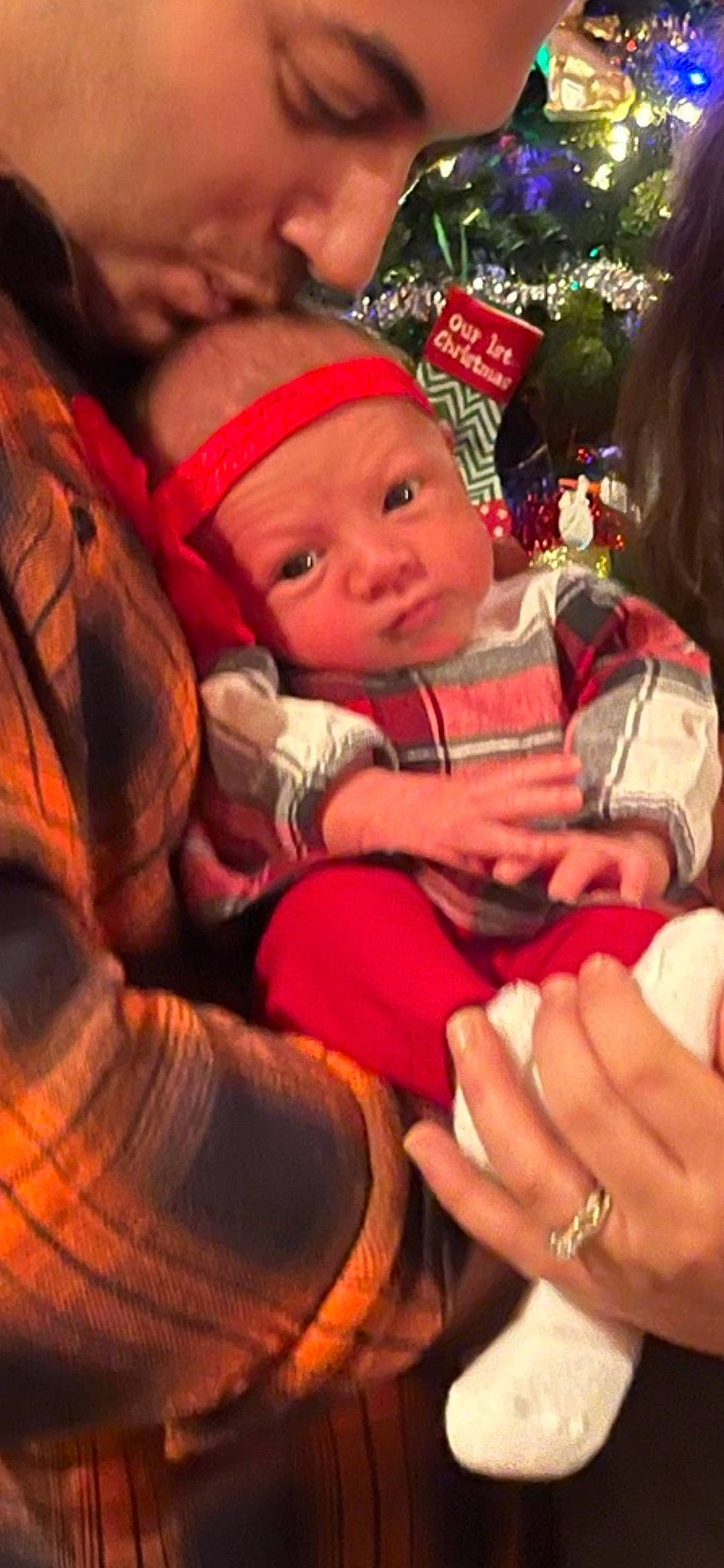 Genevieve is registered to the contest to win money with this photo: baby, carmine, christmas, christmas_eve, christmas_ornament, costume_hat, event, fictional_character, finger, gesture, happy, headwear, holiday, lap, nail, person, red, santa_claus, thumb, toddler