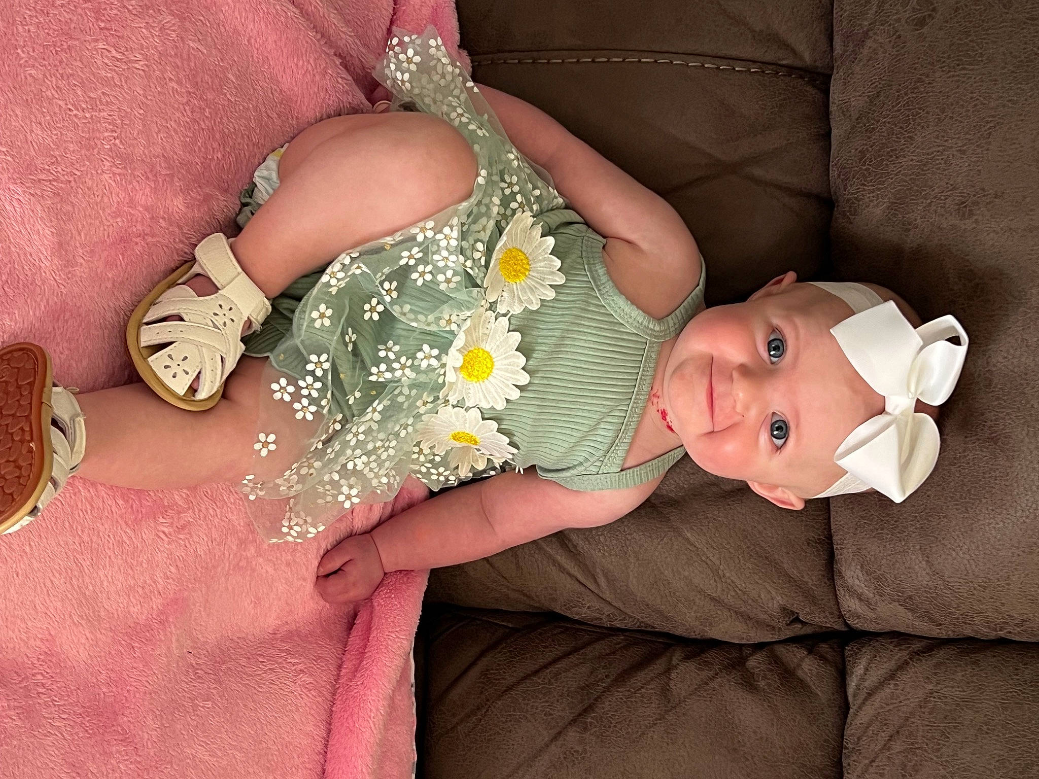 Lyla is registered to the contest to win money with this photo: arm, baby, baby_toddler_clothing, dress, finger, flower, gesture, hand, headwear, human_body, joy, leg, nail, person, petal, pink, skin, sunglasses, textile, thigh