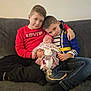 Noéline a rejoint le concours — aidez-le/la à gagner de superbes lots ! child, baby, boys, couch, sitting, smiling, holding, toy, stuffed_animal, headband, clothing, jeans, sweatshirt, indoor, family, siblings, affection, casual, relaxed, home