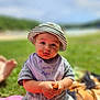 baby, child, hat, bib, food, messy_face, outdoor, grass, blanket, sunny, summer, sitting, cute, portrait, young_child, clothing, nature, daylight, person, closeup