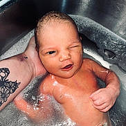 Kinley joined the competition — help win amazing prizes! newborn, baby, infant, child, bath, bathtub, sink, water, bubbles, soap, wet, naked, winking, face, portrait, hand, adult, tattoo, indoor, closeup