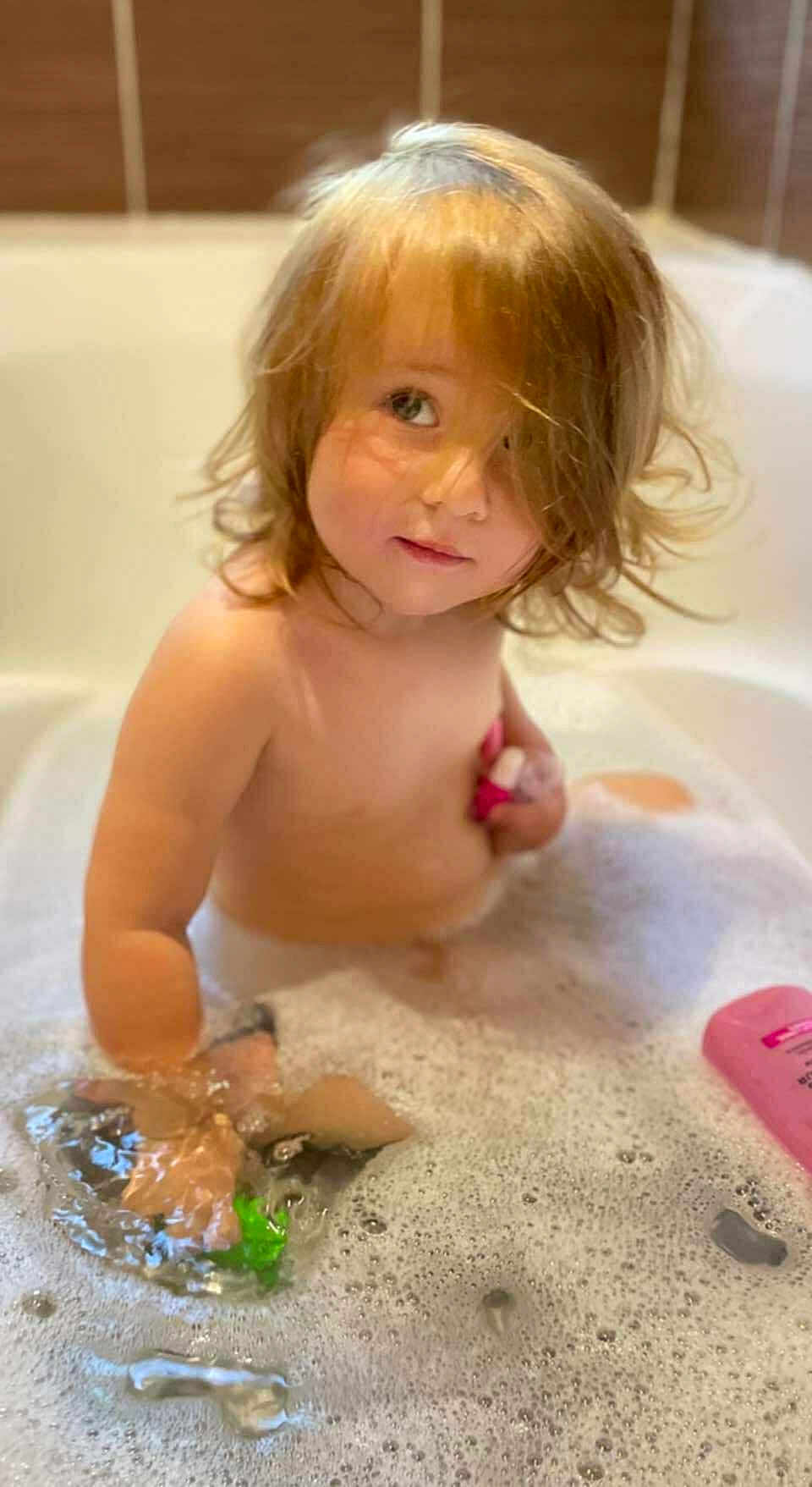 Dahlia participe au concours pour gagner de l'argent avec cette photo : toddler, child, bath, bathtub, bubbles, foam, water, toy, pink, hair, skin, bathroom, playing, cute, young_child, indoor, person, relaxing, fun, cleaning