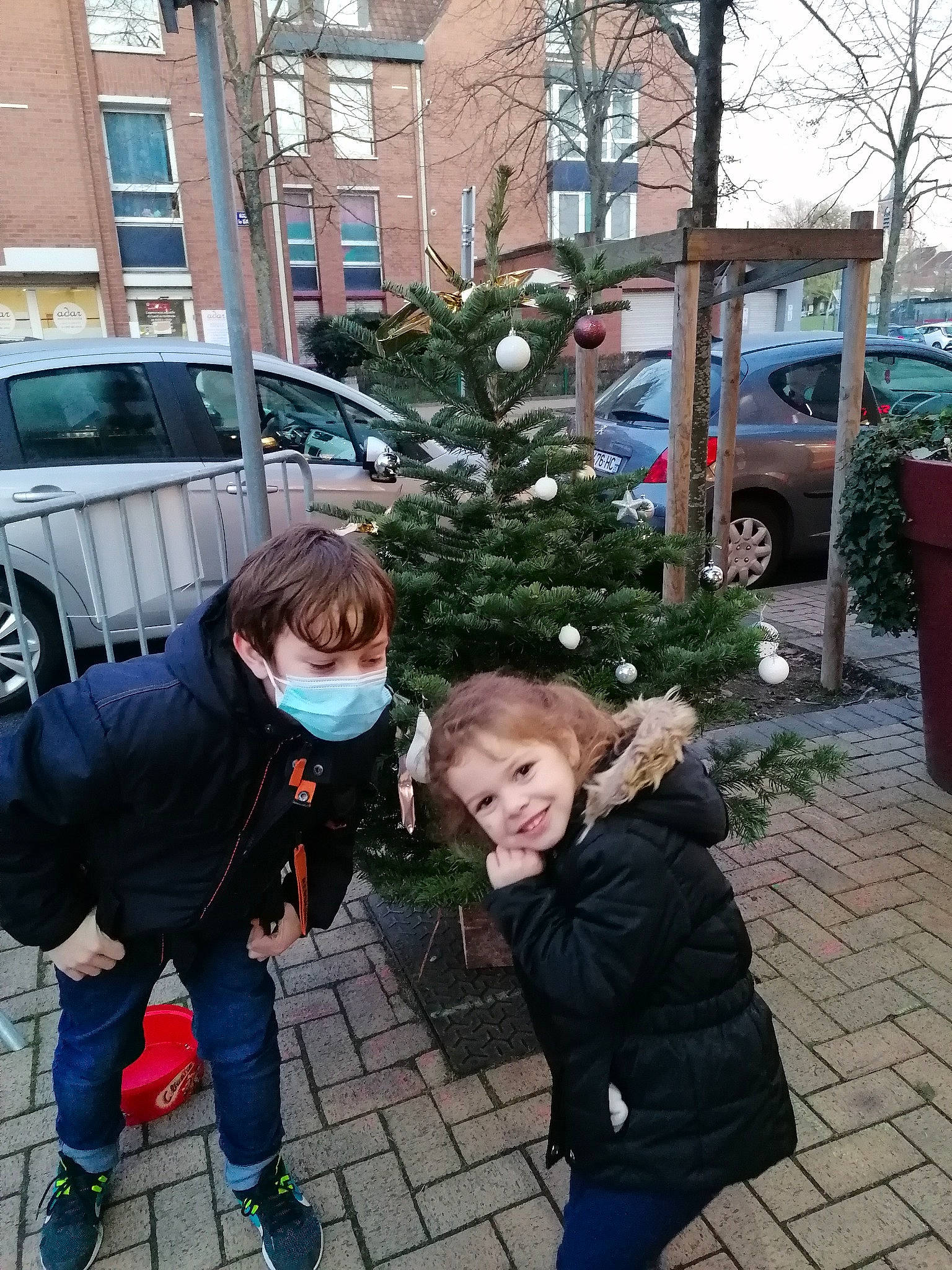 Lila participe au concours pour gagner de l'argent avec cette photo : christmas_decoration, christmas_eve, coat, conifer, denim, family_car, flowerpot, holiday, human, jacket, jeans, joy, leg, outerwear, parking, person, snapshot, street_fashion, trousers, vehicle_door