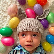 Reuben joined the competition — help win amazing prizes! baby, child, knitted_hat, bunny_ears, easter_eggs, colorful, plastic_eggs, plaid_shirt, suspenders, blanket, soft_texture, portrait, indoors, cute, infant, headwear, holiday, spring, looking_away, laying_down