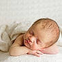 baby, newborn, sleeping, infant, blanket, bedding, portrait, face, head, hands, cheeks, soft_light, closeup, peaceful, skin, hair, resting, studio_photography, cozy, texture