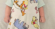 Ramey is registered to the contest to win money with this photo: baby, infant, child, face, overalls, clothing, winnie_the_pooh, tigger, eeyore, piglet, footwear, barefoot, lying_down, portrait, cute, indoors, soft_surface, expression, baby_clothes, colorful