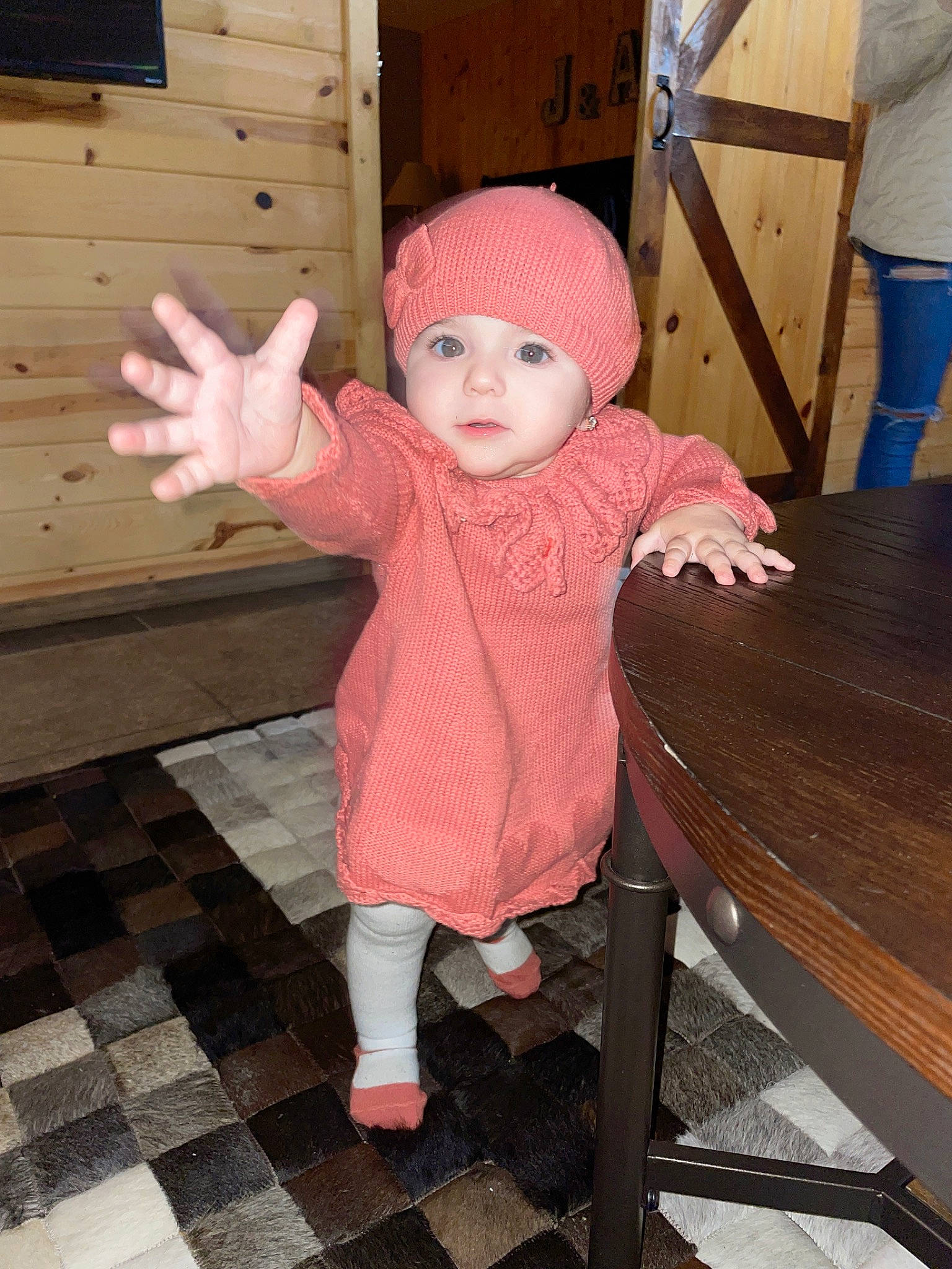 Briana is registered to the contest to win money with this photo: arm, baby, baby_toddler_clothing, cap, child, flooring, fun, headwear, human_leg, leisure, magenta, pattern, person, pink, sitting, skin, sleeve, standing, textile, thumb