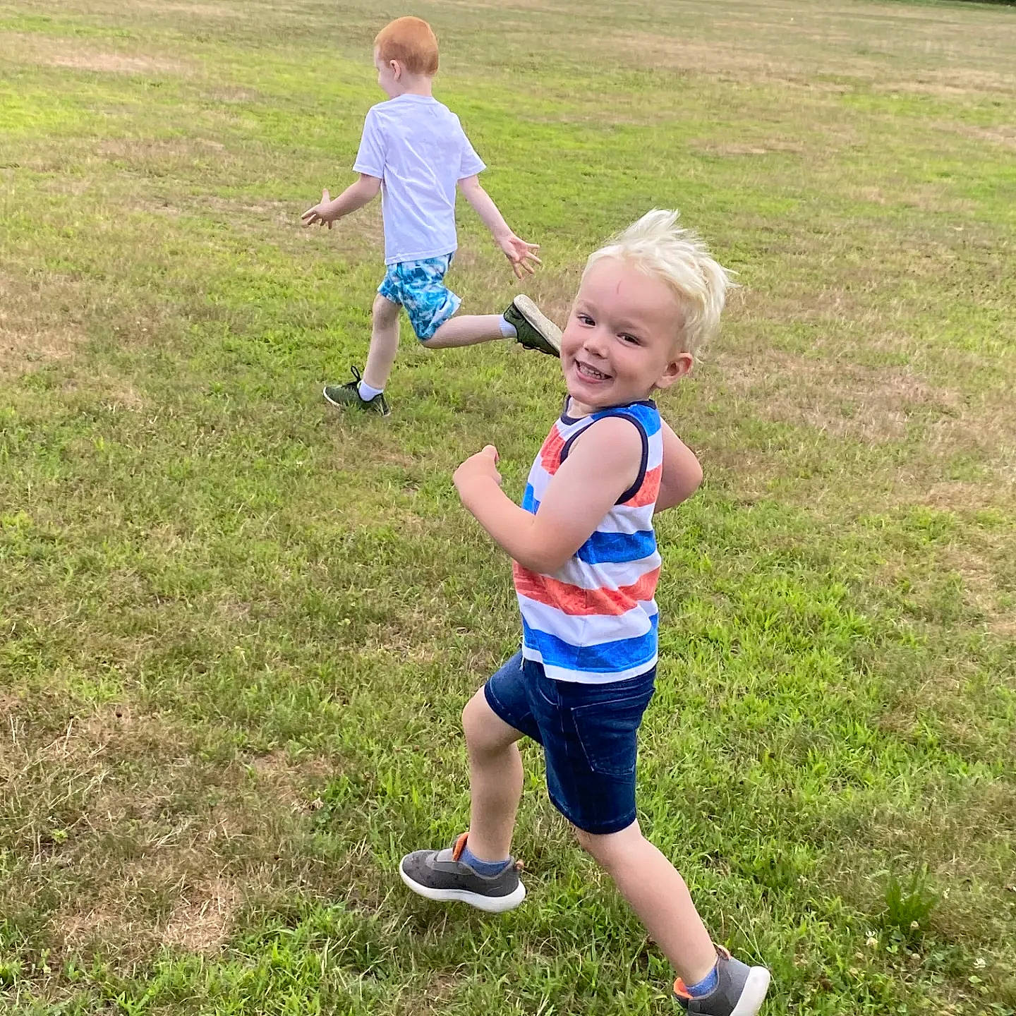 Maxwell is registered to the contest to win money with this photo: baby_toddler_clothing, child, fun, gesture, grass, grass_family, grassland, happy, joy, landscape, lawn, leisure, meadow, natural_environment, people_in_nature, person, public_space, recreation, shorts, smile