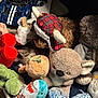 Lucy joined the competition — help win amazing prizes! cat, stuffed_animal, toy, plush, sleeping, cozy, fabric, animal_hat, car_toy, shark_plush, koala_plush, dinosaur_plush, green_toy, brown_toy, patterned_hat, soft_texture, indoor, closeup, collection, pile