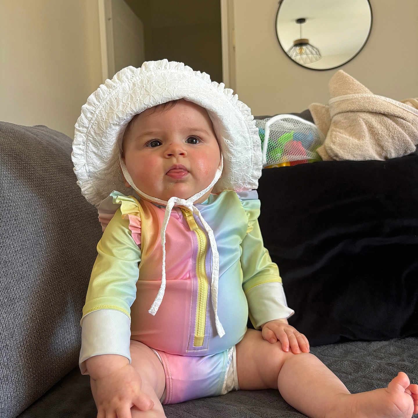 Alma a rejoint le concours — aidez-le/la à gagner de superbes lots ! baby, bonnet, child, colorful_clothing, couch, curious, face, foot, furniture, hand, home, indoors, infant, mirror, pastel_colors, plush, sitting, soft_lighting, tongue_out, towel
