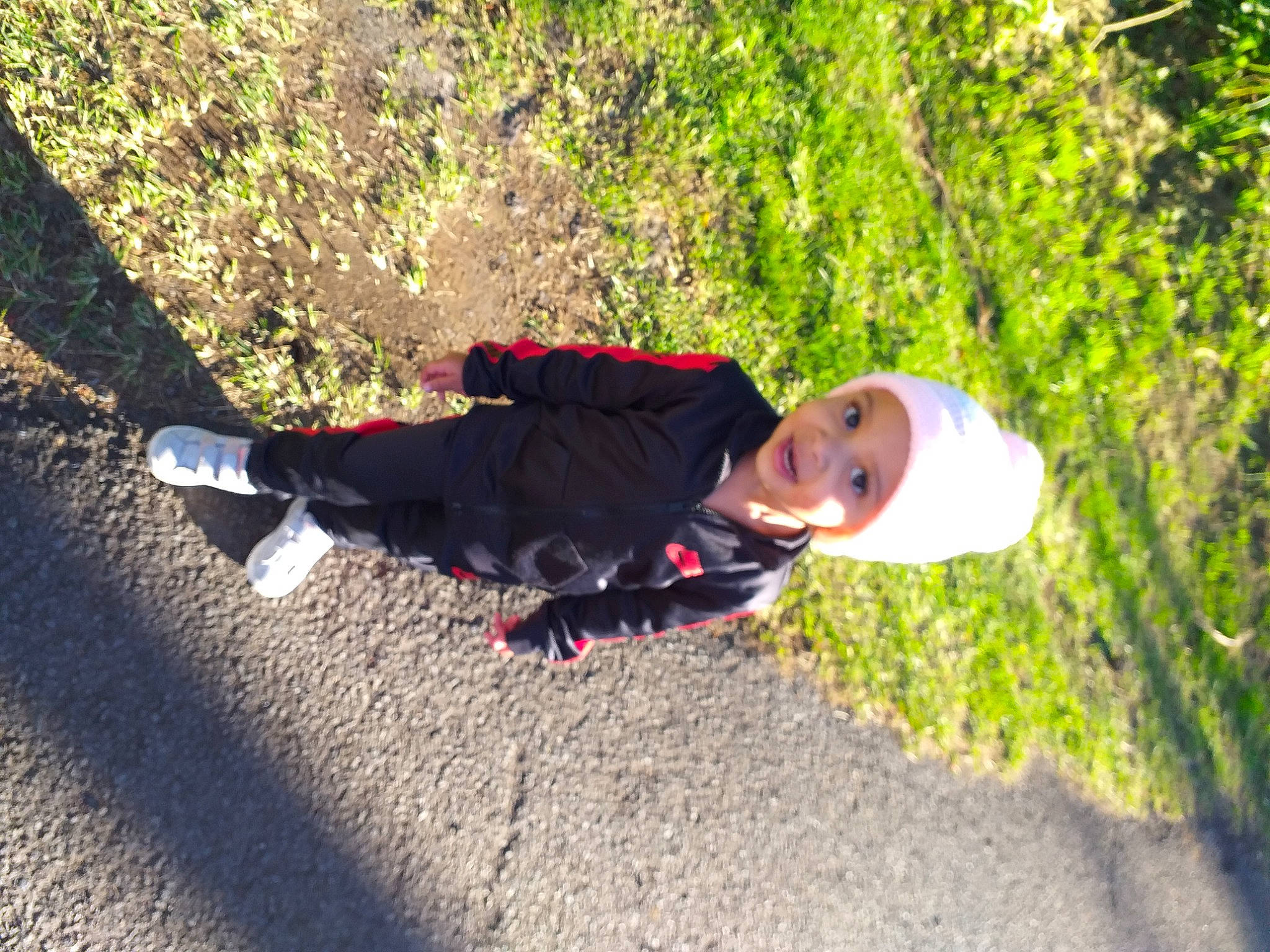 Milla a rejoint le concours — aidez-le/la à gagner de superbes lots ! asphalt, child, fun, grass, headwear, landscape, leisure, people_in_nature, person, plant, recreation, road, road_surface, shadow, sidewalk, sitting, sunlight, toddler, tree, vacation