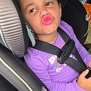 Amiyah joined the competition — help win amazing prizes! child, girl, car_seat, curly_hair, hair_bow, purple_shirt, seatbelt, car_interior, puckered_lips, funny_face, safety, cute, young_child, portrait, seat, buckled_up, car, expression, casual_clothing, indoor