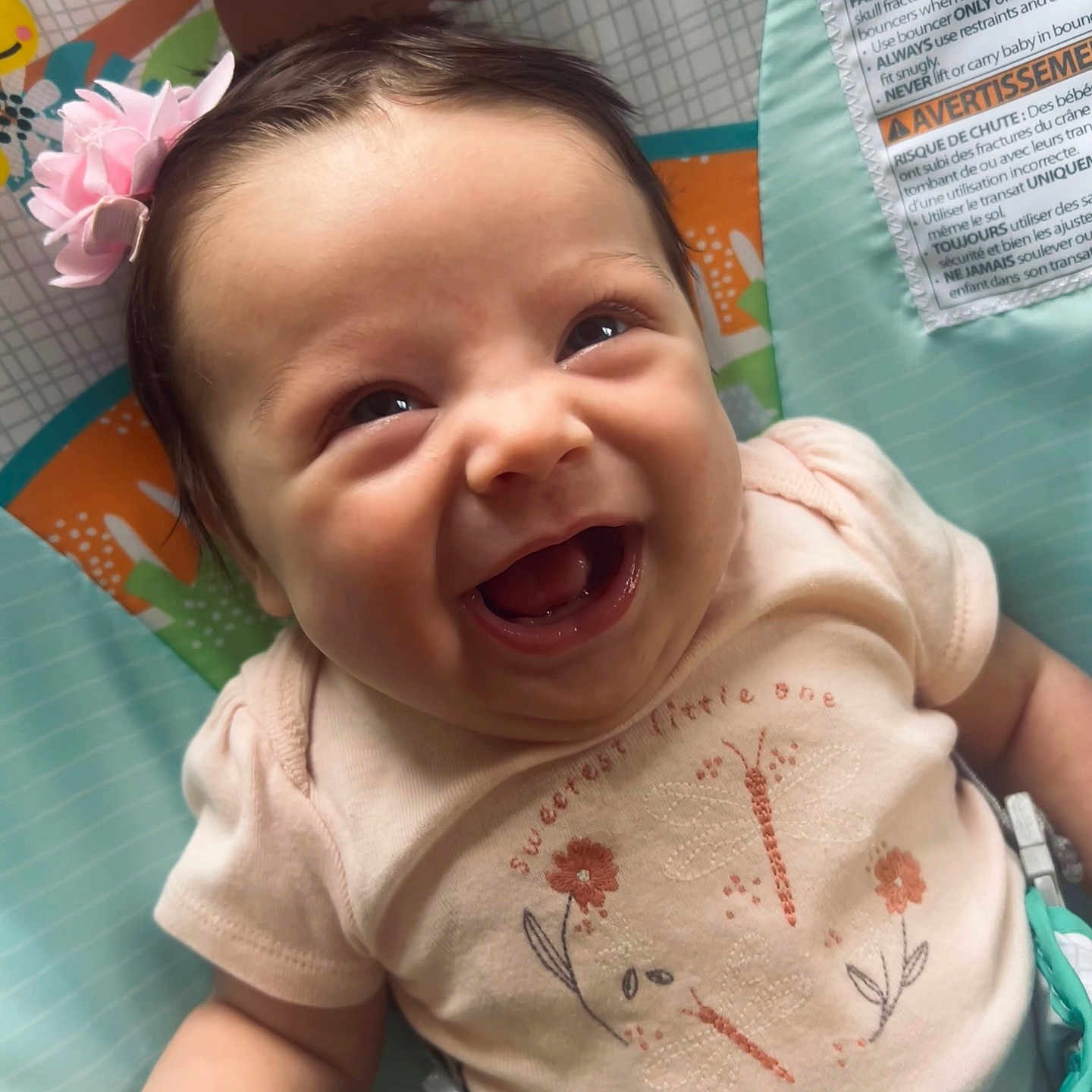 Elsie joined the competition — help win amazing prizes! baby, smiling, headband, pink_flower, infant, clothing, baby_seat, colorful, cute, happy, face, human, child, closeup, sitting, cute_expression, indoors, person, portrait, toy