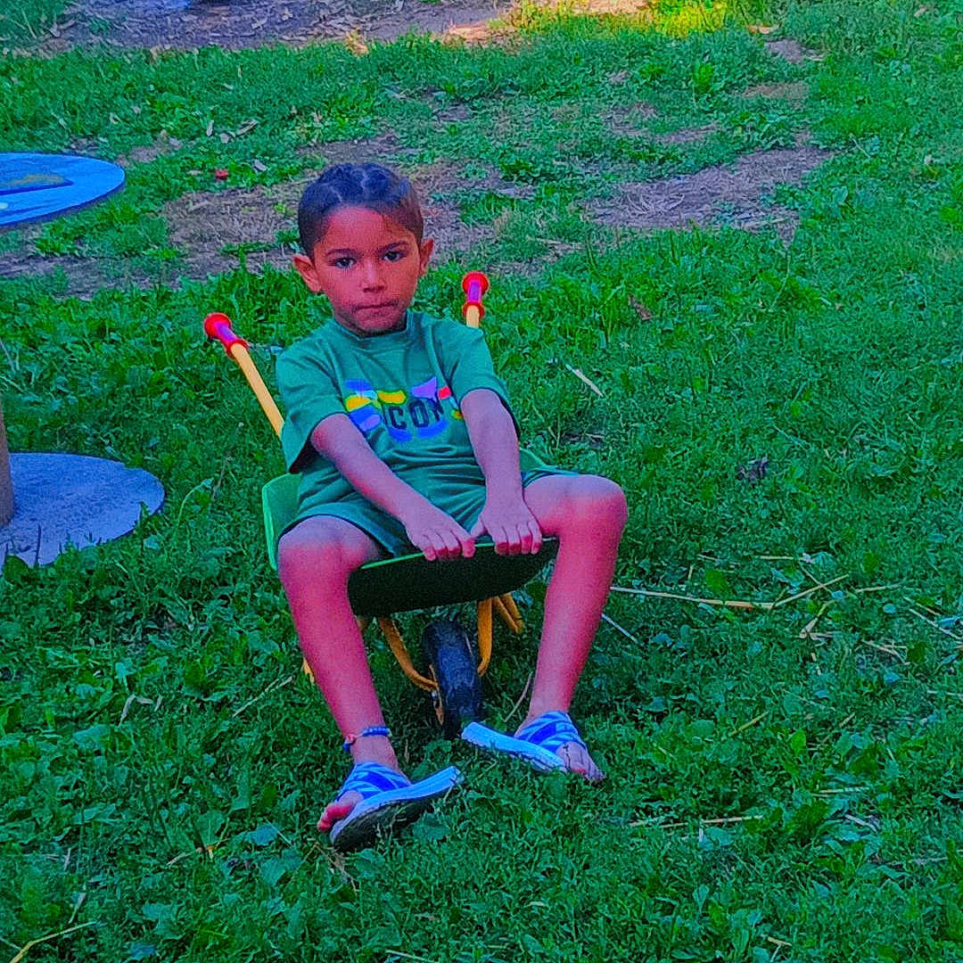 Esteban a rejoint le concours — aidez-le/la à gagner de superbes lots ! blue_shoes, casual, child, childhood, footwear, garden, grass, green_tshirt, greenery, nature, outdoor, playtime, recreation, serious_expression, small_wheel, summer_clothes, sunlight, toy, wheelbarrow, yard