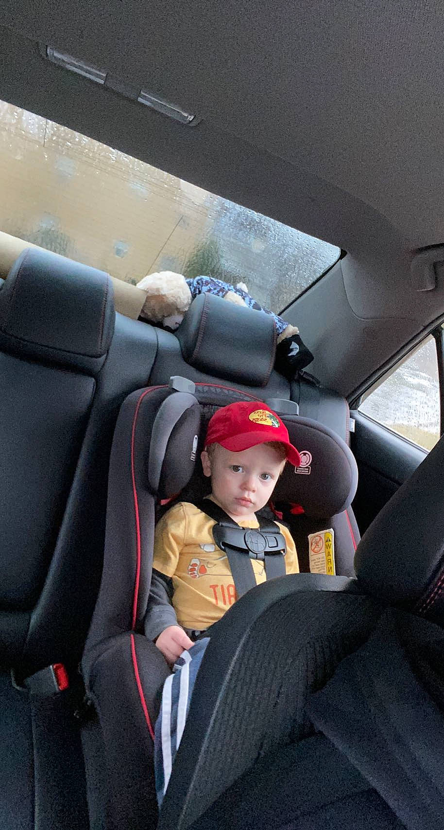 Haiden is registered to the contest to win money with this photo: auto_part, automotive_design, automotive_exterior, baby, car, car_seat, car_seat_cover, comfort, family_car, head_restraint, headwear, mode_of_transport, motor_vehicle, person, personal_luxury_car, seat_belt, steering_part, steering_wheel, toddler, vehicle