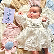 Ayla participe au concours pour gagner de l'argent avec cette photo : baby, infant, child, white_dress, plush_toy, flower, blanket, card, soft_texture, cute, lying_down, indoors, portrait, newborn, one_month, curious_expression, chubby_cheeks, pink, blue, decorative