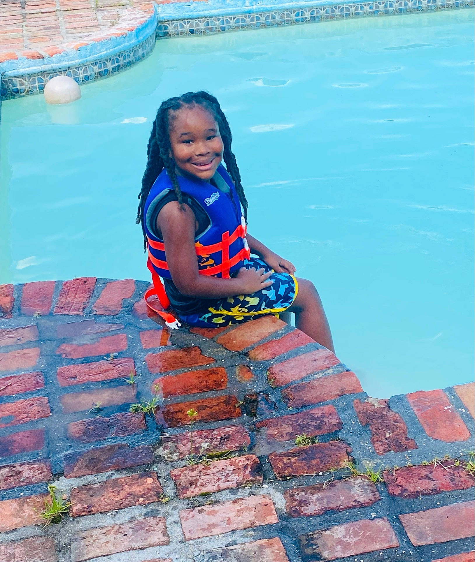 Brennan is registered to the contest to win money with this photo: aqua, azure, bathing, electric_blue, flooring, fun, happy, human_leg, joy, leisure, leisure_centre, pattern, person, recreation, sitting, smile, swimming_pool, swimwear, thigh, vacation