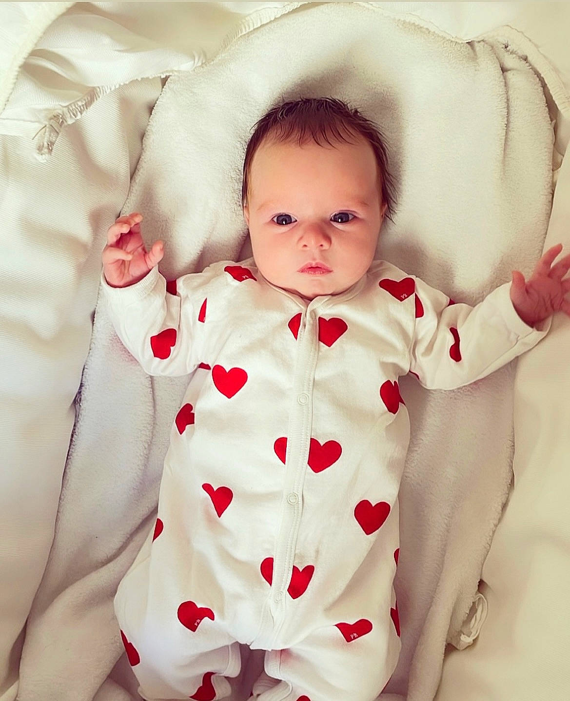 Hanaë participe au concours pour gagner de l'argent avec cette photo : arm, baby, baby_toddler_clothing, cheek, collar, eye, face, gesture, happy, head, human_body, iris, lip, mammal, neck, person, skin, sleeve, textile, toddler