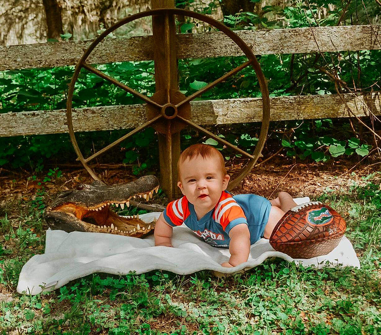 Waylon is registered to the contest to win money with this photo: baby, baby_toddler_clothing, botany, fence, grass, grass_family, green, groundcover, happy, landscape, lawn, leaf, leisure, outdoor_furniture, people_in_nature, person, plant, recreation, smile, toddler