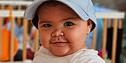 Anna-Maria participe au concours pour gagner de l'argent avec cette photo : apparel, baby, baseball_cap, blurred_background, cap, child, chubby_cheeks, closeup, cute, face, happy, headwear, indoor, infant, person, play_area, portrait, smile, white_shirt, young