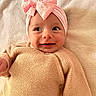 baby, infant, smile, pink_bow, headband, knitted_sweater, cozy, soft_blanket, happy, cute, portrait, child, lying_down, indoors, closeup, warm_colors, small_person, baby_clothes, adorable, face