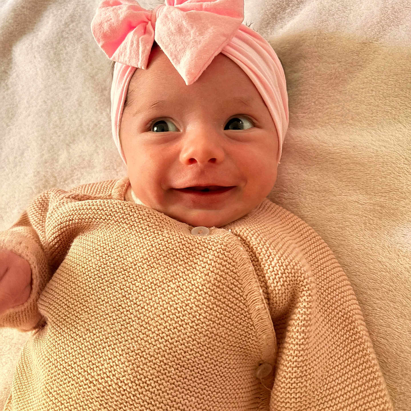 Ambre a rejoint le concours — aidez-le/la à gagner de superbes lots ! baby, infant, smile, pink_bow, headband, knitted_sweater, cozy, soft_blanket, happy, cute, portrait, child, lying_down, indoors, closeup, warm_colors, small_person, baby_clothes, adorable, face
