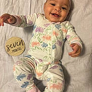 Indigo is registered to the contest to win money with this photo: applique, baby, babylaughing, bodypart, cap, clothing, face, finger, hand, happy, hat, head, newborn, pajamas, pants, pattern, person, photography, portrait, smile