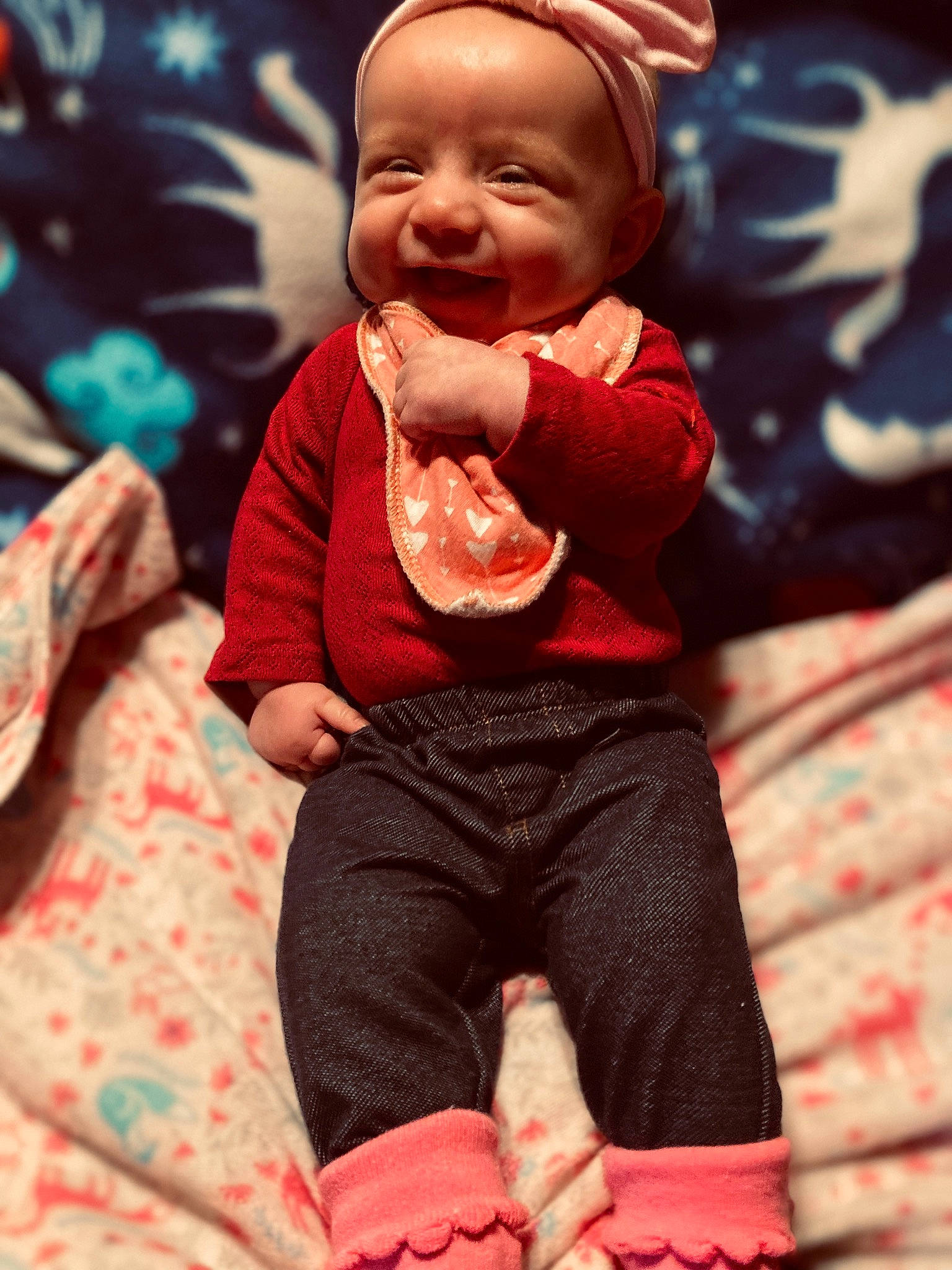 Jessica is registered to the contest to win money with this photo: arm, baby, baby_toddler_clothing, cap, cheek, cool, face, finger, happy, human_body, lap, outerwear, person, pink, red, skin, sleeve, smile, sock, thumb