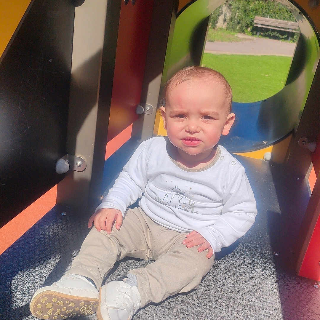 Neïven a rejoint le concours — aidez-le/la à gagner de superbes lots ! baby, clothing, face, footwear, grass, head, indoors, jeans, outdoorplayarea, outdoors, pants, person, photography, plant, playarea, portrait, shoe, sitting, sneaker, wood