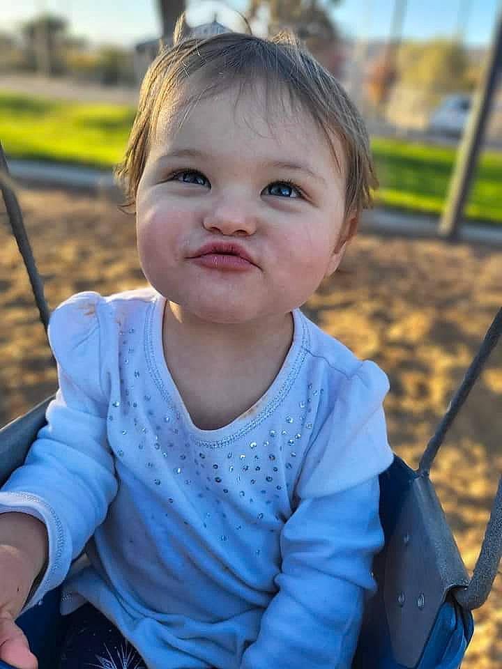 Leah joined the competition — help win amazing prizes! baby_toddler_clothing, cheek, eye, facial_expression, fun, grass, happy, head, iris, leaf, leisure, nose, person, public_space, recreation, skin, smile, standing, summer, swing